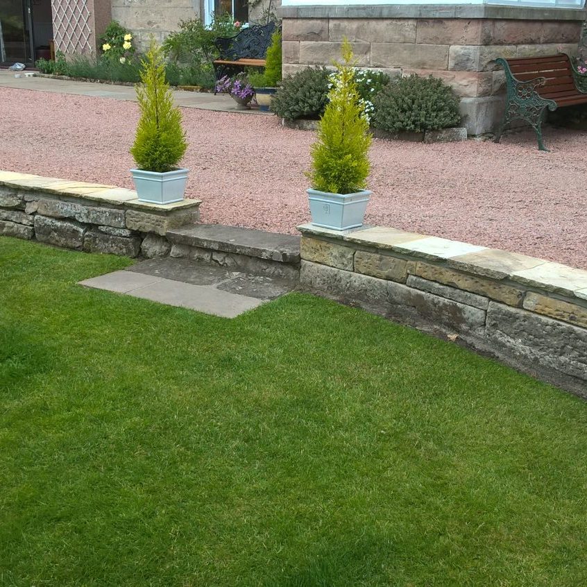 stone driveway with step down to garden